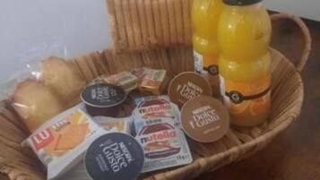 Una cesta con diversos alimentos y una botella de jugo.