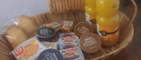 A basket containing various food items and a juice bottle.