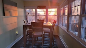 A dining area with a table and chairs, large windows with a view of the outside, and a sign that reads "The Lake is my happy place." - Lakeview Ashtabula, OH - 5 min to GOTL - Deck - King - Wineries - Lake Erie  (Ashtabula)