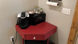 A kitchenette with a coffee maker, microwave, and various kitchen items on a red countertop. - Private apartment in a quiet neighborhood with lots of trees and privacy. (Weaverville)