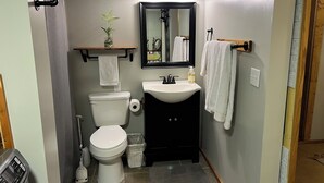 A compact bathroom with a toilet, sink, and shower. - Private apartment in a quiet neighborhood with lots of trees and privacy. (Weaverville)