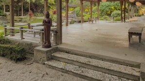 A covered pavilion with a statue, steps leading up to it, and a garden in the background. - Cozy Lake House: Unique Japanese Garden Stay in Miami (Homestead)