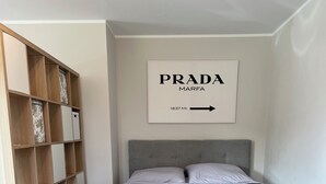 A bedroom with a bed, a wardrobe, and a framed sign on the wall. - Modern vacation apartment with feel-good terrace in Beerfelden (Oberzent)