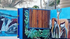 A mural with a waterfall and animals.