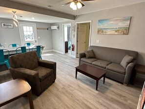 A living room with a sofa, armchair, coffee table, and a painting on the wall. - Cottage on Strip w/ 3 BDs 2 BAs (Geneva)