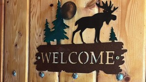 Un senyal de fusta amb la silueta d'un alç i arbres, i la paraula 'WELCOME' escrita al damunt.