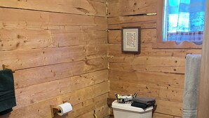 Un bany amb panells de fusta, amb vàter, bidet i rentapel.