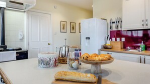 A modern kitchen with a central island, a white refrigerator, and various kitchen appliances. - 6 bedroom accommodation in Beauly, near Inverness (Beauly, near Inverness)