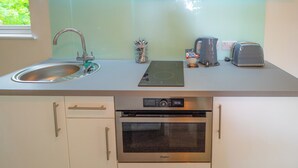 Een moderne keuken met een roestvrijstalen spoelbak, een inbouwoven en een broodrooster.