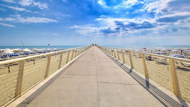 A beach promenade with a concrete walkway, beach umbrellas, and a clear view of the sea. - 2 bedroom stunning home in Camaiore (Camaiore)