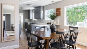 Una cocina moderna con armarios grises, una mesa de comedor de madera y sillas negras.