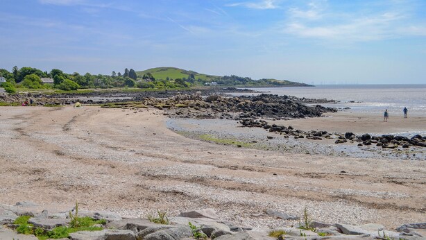 A beach with rocky terrain and a distant view of a hill. - 3 bedroom accommodation in Rockcliffe, near Dalbeattie (Rockcliffe, near Dalbeattie)