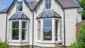 A white house with two bay windows and a satellite dish. - 3 bedroom accommodation in Rockcliffe, near Dalbeattie (Rockcliffe, near Dalbeattie)