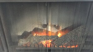 A fireplace with visible logs and flames. - Nautical theme retreat located in the Ivory Mansion  (L'Anse)