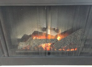 Enjoy a cozy ambiance by the fireplace, complete with a heating element and safety mesh screen.
