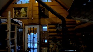 A log cabin interior with a wooden staircase, a door with a window, and a stone wall. - Off the grid cabin on private land surrounded by national forest. (Laramie)