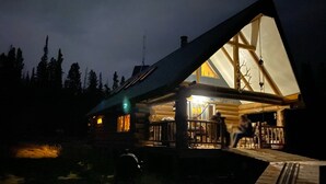 A lodge with a large, triangular roof and a wooden deck. - Off the grid cabin on private land surrounded by national forest. (Laramie)