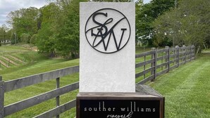 Une plaque avec un logo et l’inscription « Southern Williams Vineyard » sur un piédestal en pierre.