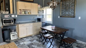 A compact kitchen with a wooden table and bench, a microwave, and a sink. - Light and Airey new apartment on Apple Orchard minutes from Sylvan Beach (Blossvale)