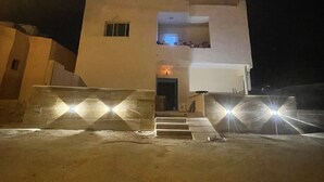 A white building with a small entrance and steps leading up to it. - RoadHouse (Wadi Musa)