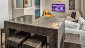 A modern kitchen with a glass-top island, wicker furniture, and a sofa. - St Simons: 3 Bedroom, Walk to A&M, King Beds (Bryan)
