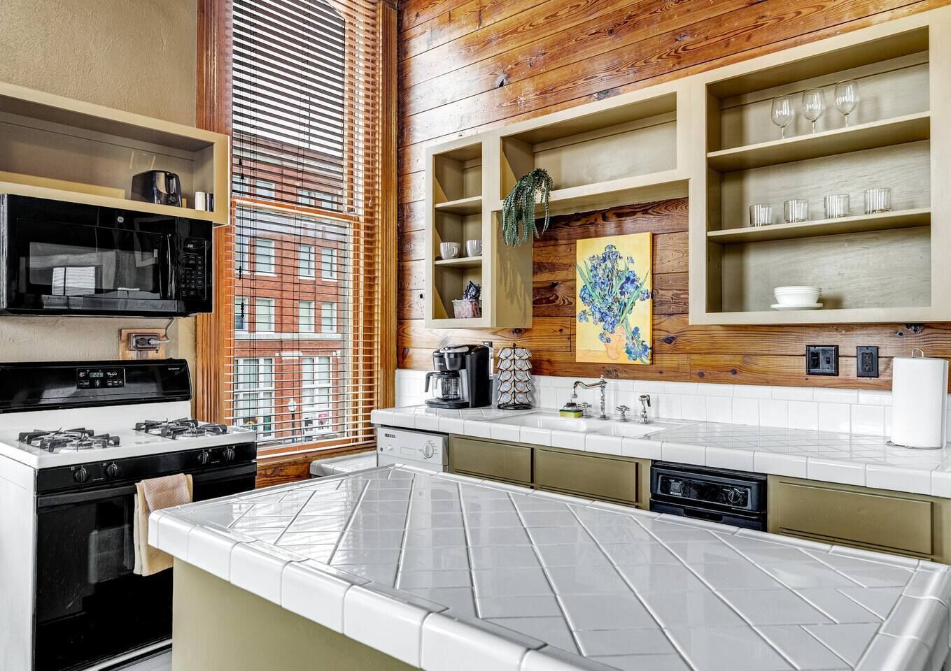 A modern kitchen with a large island, built-in appliances, and wooden accents.