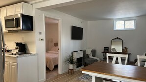 A compact living space with a kitchenette, a dining area, a bedroom, and a small sitting area.