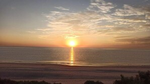 A sunset over a calm sea with a clear horizon. - Beachfront House on Beautiful Laguna Percebu Beach (San Felipe)