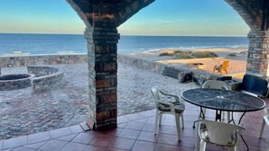 A stone patio with a view of the beach and ocean. - Beachfront House on Beautiful Laguna Percebu Beach (San Felipe)