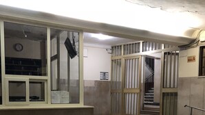 Um edifício público com chão em mosaico, escadaria e portas com grades.