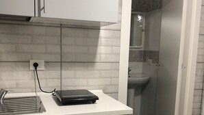Uma cozinha moderna com bancada, pia e toalha pendurada em um armário.