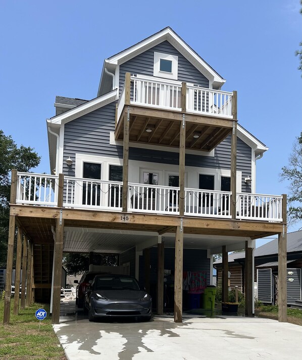 Ein zweigeschossiges Haus mit Balkon und Garage.