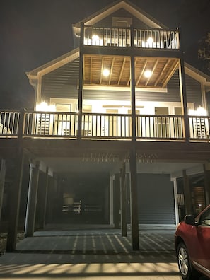 Una casa a due piani con un balcone e un garage.