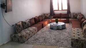 Una sala de estar con un sofá modular, alfombra estampada y una mesita de centro.