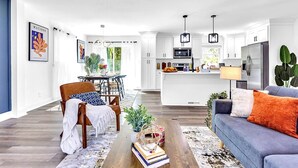 A modern kitchen with white cabinets, a central island, and a refrigerator.