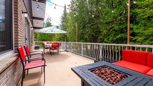 A balcony with outdoor furniture, a table with a fire pit, and string lights. - Wind Swept Pines
Newly renovated, close to water 3 bedroom cottage (Wiarton)