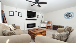 A living room with a flat-screen TV, fireplace, and a decorative gear wall piece. - Wind Swept Pines
Newly renovated, close to water 3 bedroom cottage (Wiarton)