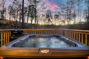 A hot tub on a wooden deck with a view of trees and a sunset. - *Pet Friendly *MtnViews *HotTub*Game Room*Fire pit (Sevierville)