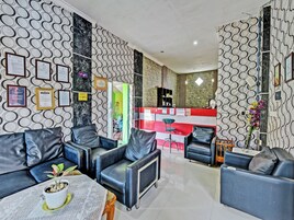 Un interior moderno con sofás de cuero, un mostrador de recepción y paredes con diseño.