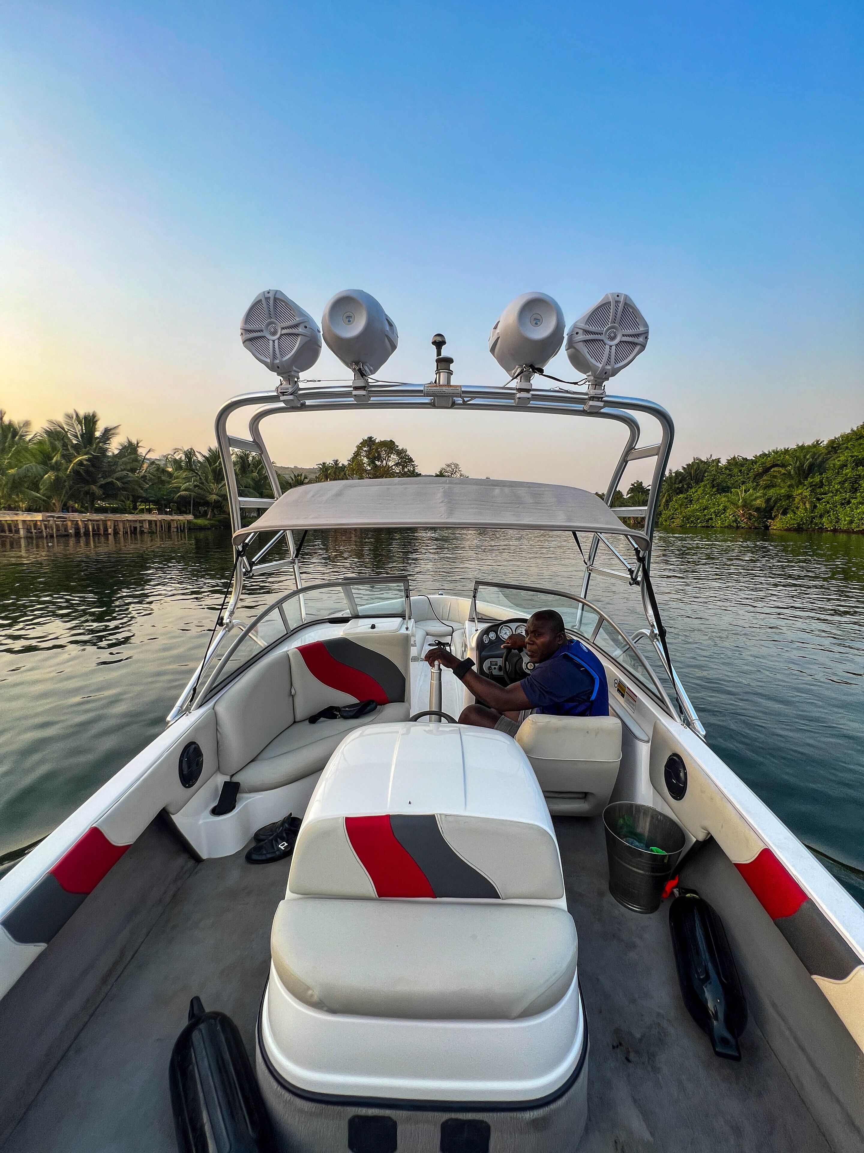 A boat with a steering wheel, two seats, and a canopy.