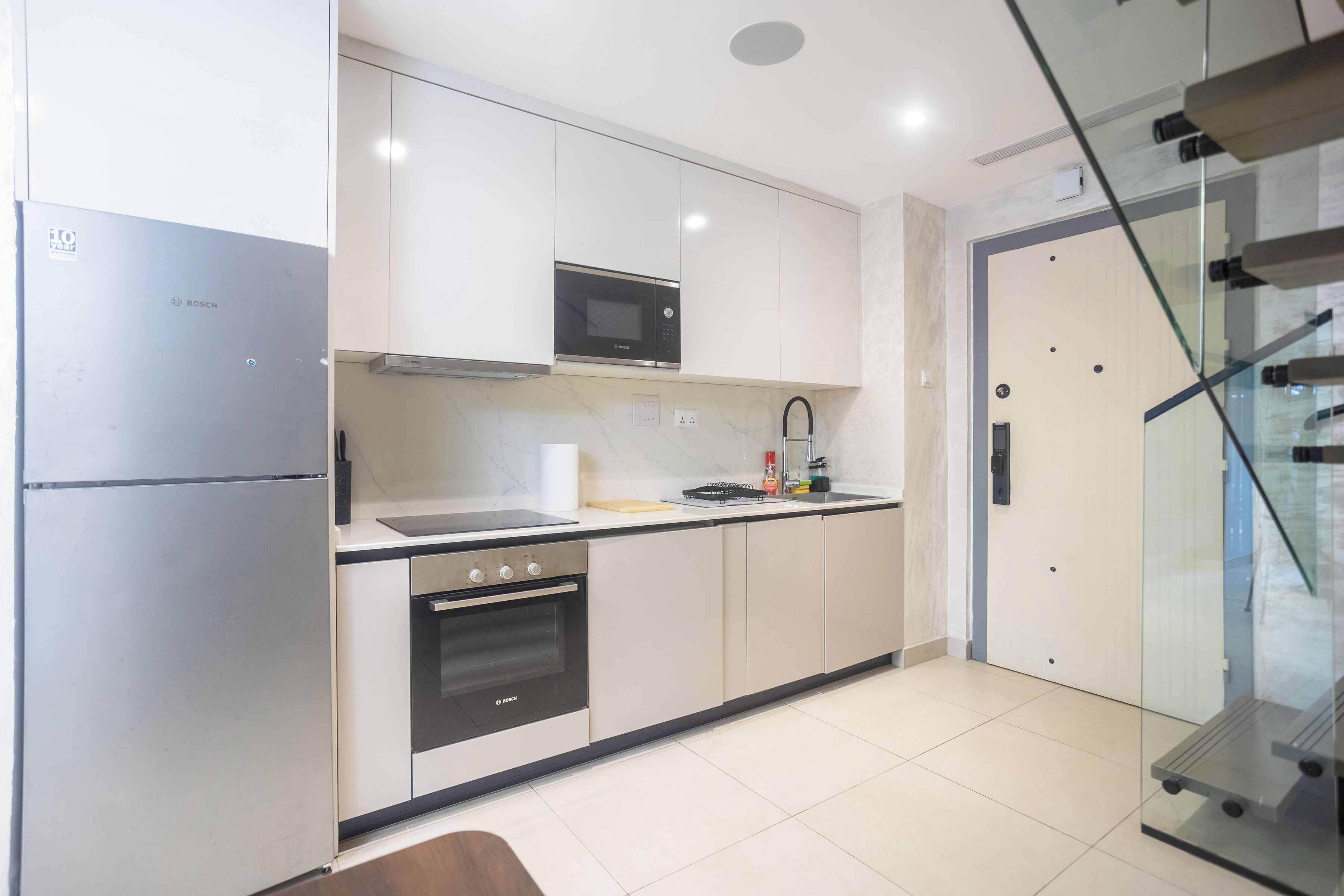 A modern kitchen with a Bosch refrigerator, oven, and microwave.