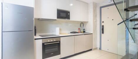 A modern kitchen with a Bosch refrigerator, oven, and microwave.