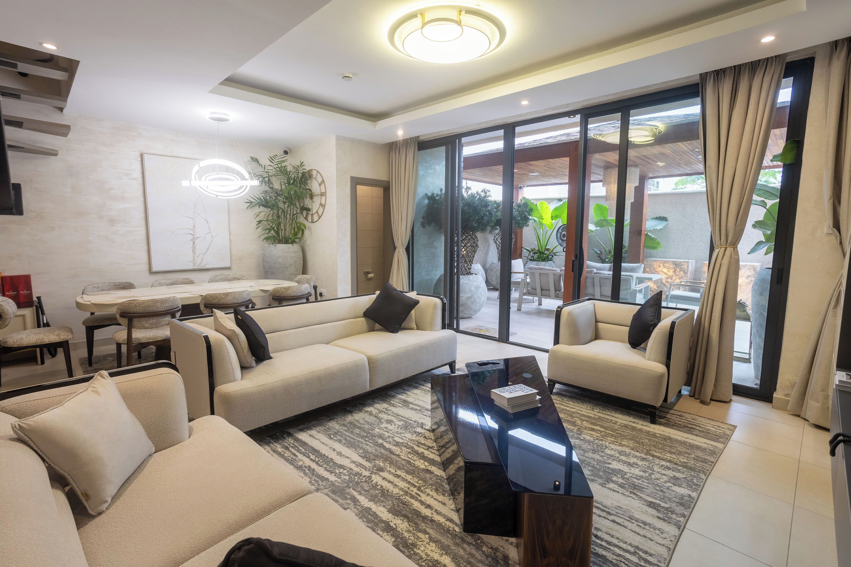 A modern living room with a sectional sofa, a coffee table, and a dining area with a table and chairs.