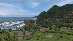 Ein Yachthafen mit Booten, ein Golfplatz und eine hügelige Landschaft mit Gebäuden.