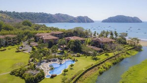Ein Resort mit mehreren Gebäuden, einem Schwimmbad und Blick auf den Ozean.