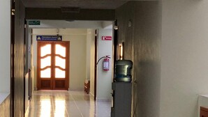 Un couloir équipé d’un extincteur, d’un distributeur d’eau et d’une porte sur laquelle est inscrit « Prohibido Pagar » (paiement interdit).