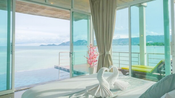 A room with a bed, a potted plant, and a view of the sea. - Smile Samui Chaweng Beach Front Resort (Koh Samui)