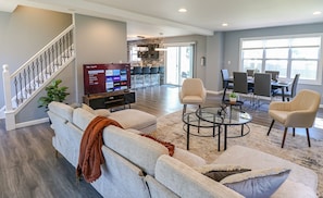Relax in this stylish living area with a large flat-screen TV, comfortable seating, and a dining table.