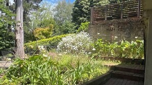 Un jardín con un sendero de ladrillo que conduce a un muro de ladrillo.