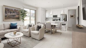 Un salon moderne comprenant un canapé, des fauteuils, une table basse et un coin repas avec une table et des chaises.